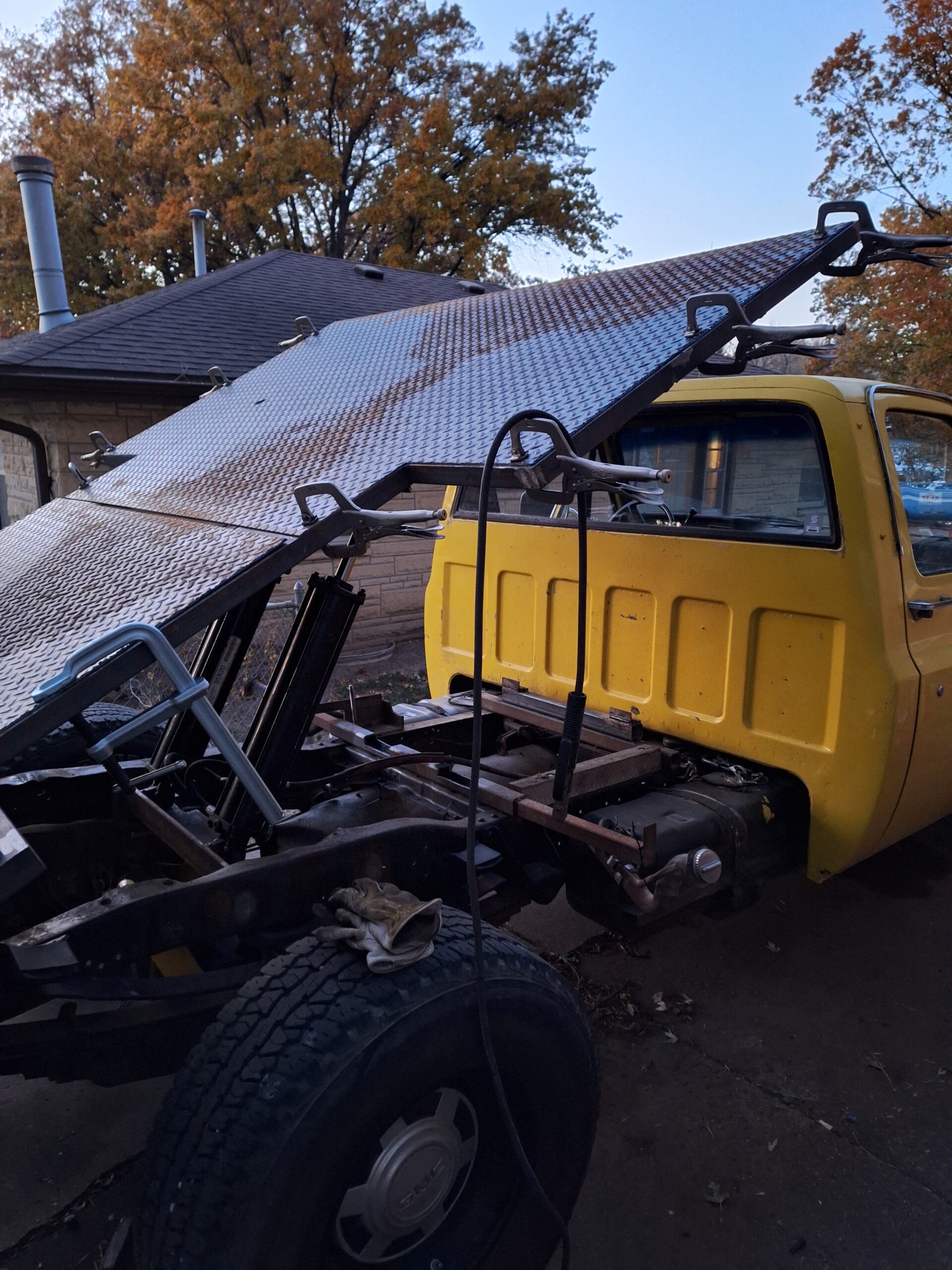 custom dump flatbed in the process of getting the deck plates welded down.  bed is raised at 35 degrees with welding clamps all around the perimeter